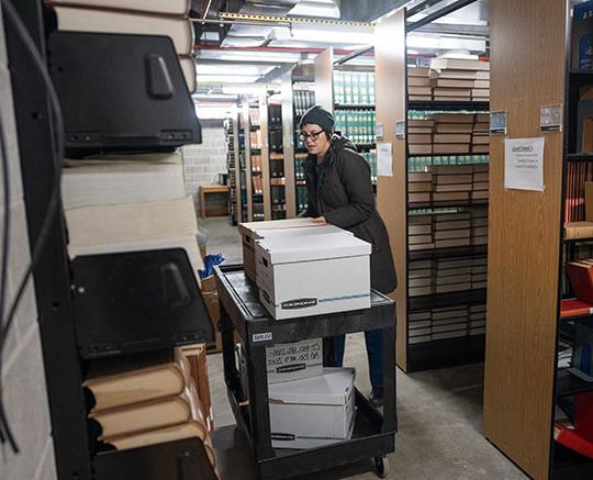 woman with hat moving a couple boxes